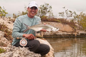 Sean Visintainer holding a small baby tarpon he caught using his Winston MX fly rod and Hatch 9 plus fly reel.