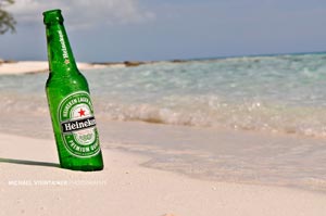 A lovely Heineken bottle posing for it's photo shoot on the white sandy beach.