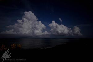 This photo is actually taken in complete darkness of a few thunderheads rolling into the island.
