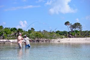 Mike giving the WOOHOO as his Bonefish  smokes line and his guide Nestor supervises.
