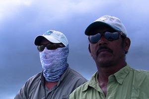 Guide Omar in deep focus while Mike Peters strips his line in during the hosted trip to Belize for bonefish.