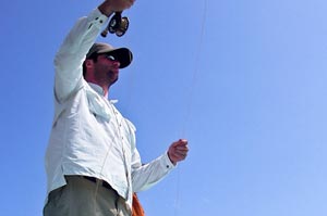 Josh casts to schools of Bonefish from guide Omars boat as he is polled across the flats of Belize.