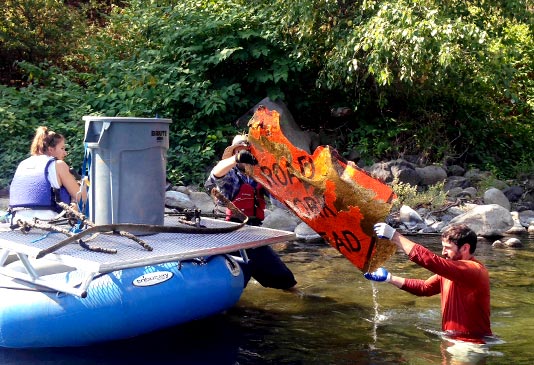 Bo Brand of Silver Bow Fly Shop loading up scrap metal out of the Spokane River.