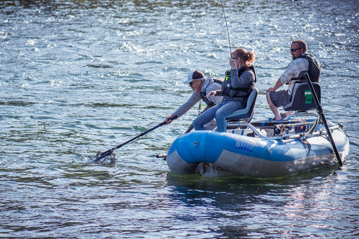 Spokane River fishing guide Jake Hood nets a first fish on fly rod for guest.