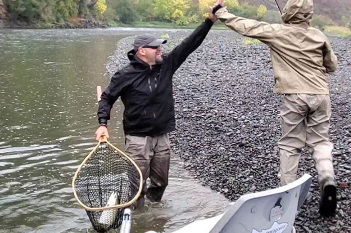 Silver Bow guide Britten Jay celebrating a Grande Ronde steelhead in the net.