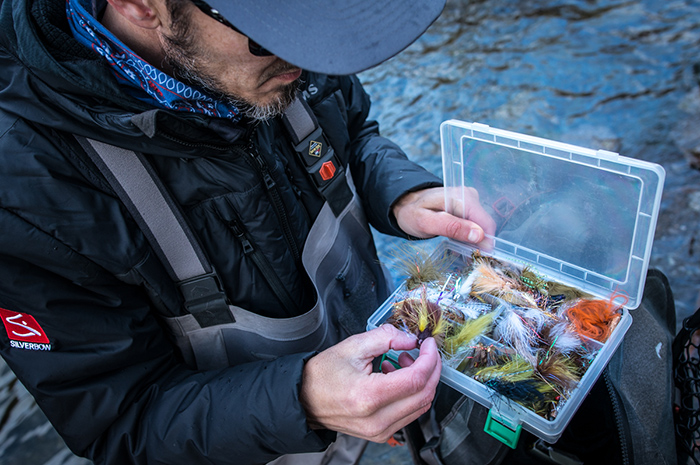 Mike Visintainer filtering through a box of streamer flies looking for the lucky winner.