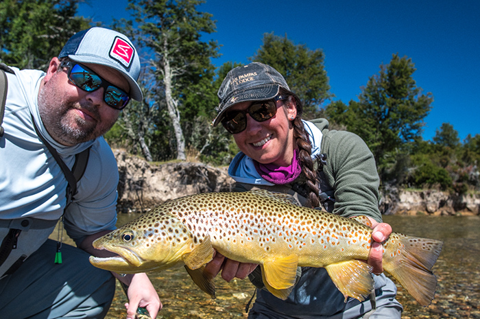 Marcela Appelhanz of the Las Pampas Lodge hoist a large brown trout caught on a dry fly in southern Patagonia.