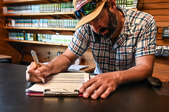 Silver Bow Fly Shop Guide Manager, Bo Brand, taking down notes for Spokane River Guided Fly Fishing Trips.