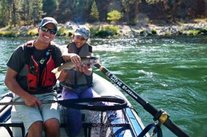 9 year old Daazhraii with one of her first fly caught rainbows from the Spokane River.