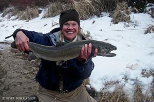 Nancy M posing with a massive bull trout caught in the dead of winter in Montana.