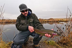 Mark Poirier checking out a nice long rainbow trout from Rocky Ford Creek in Washington.